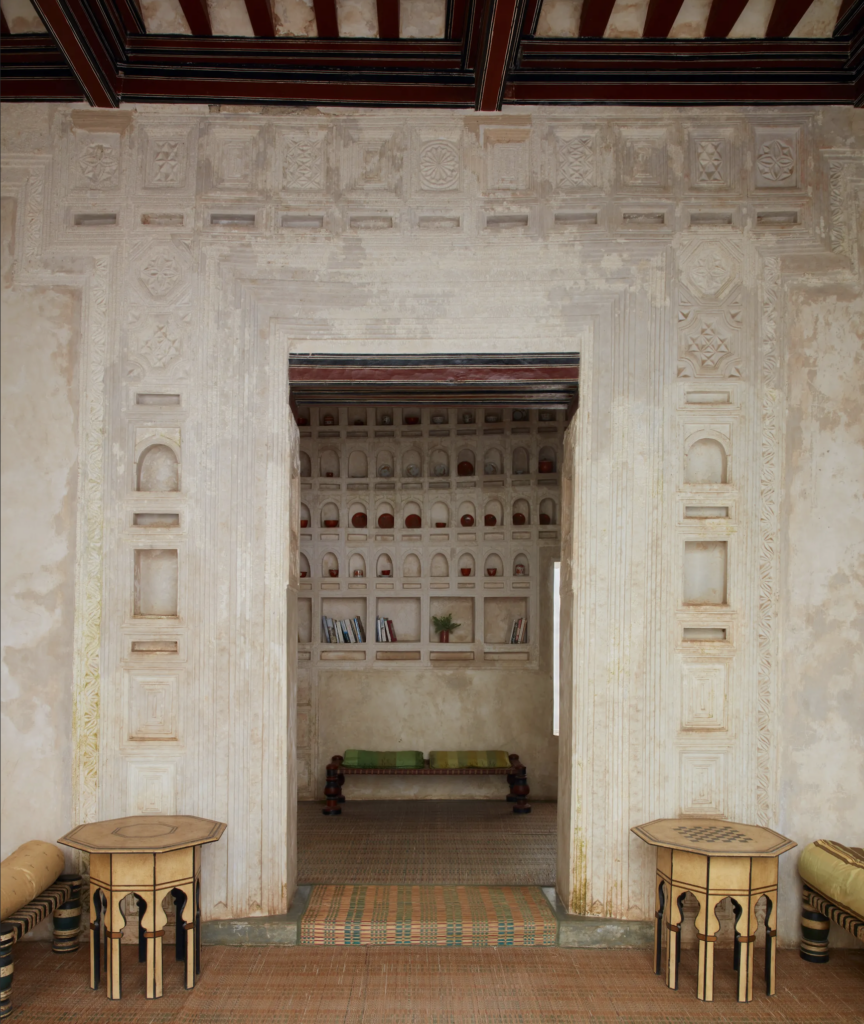 Traditional interior with geometric wall carvings and built-in shelving.