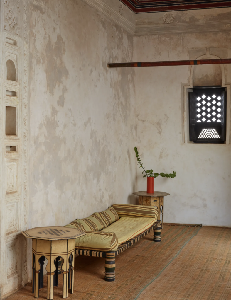 Lounge area with a traditional wooden daybed and geometric side tables.