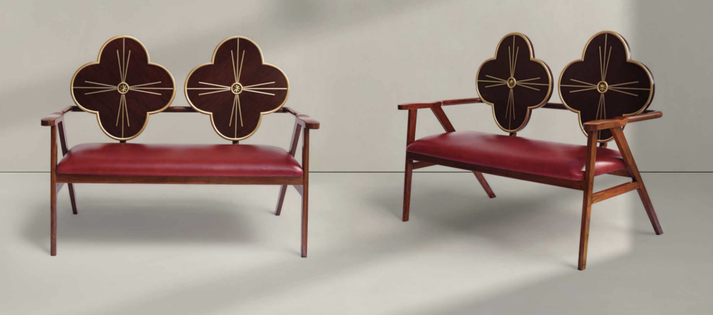 Red Leather and Wood Floral Bench – A wooden bench with a deep red leather seat cushion and a backrest shaped like two four-petaled flowers, featuring gold-lined embellishments. The rich hues and intricate details create a luxurious, vintage-inspired design.